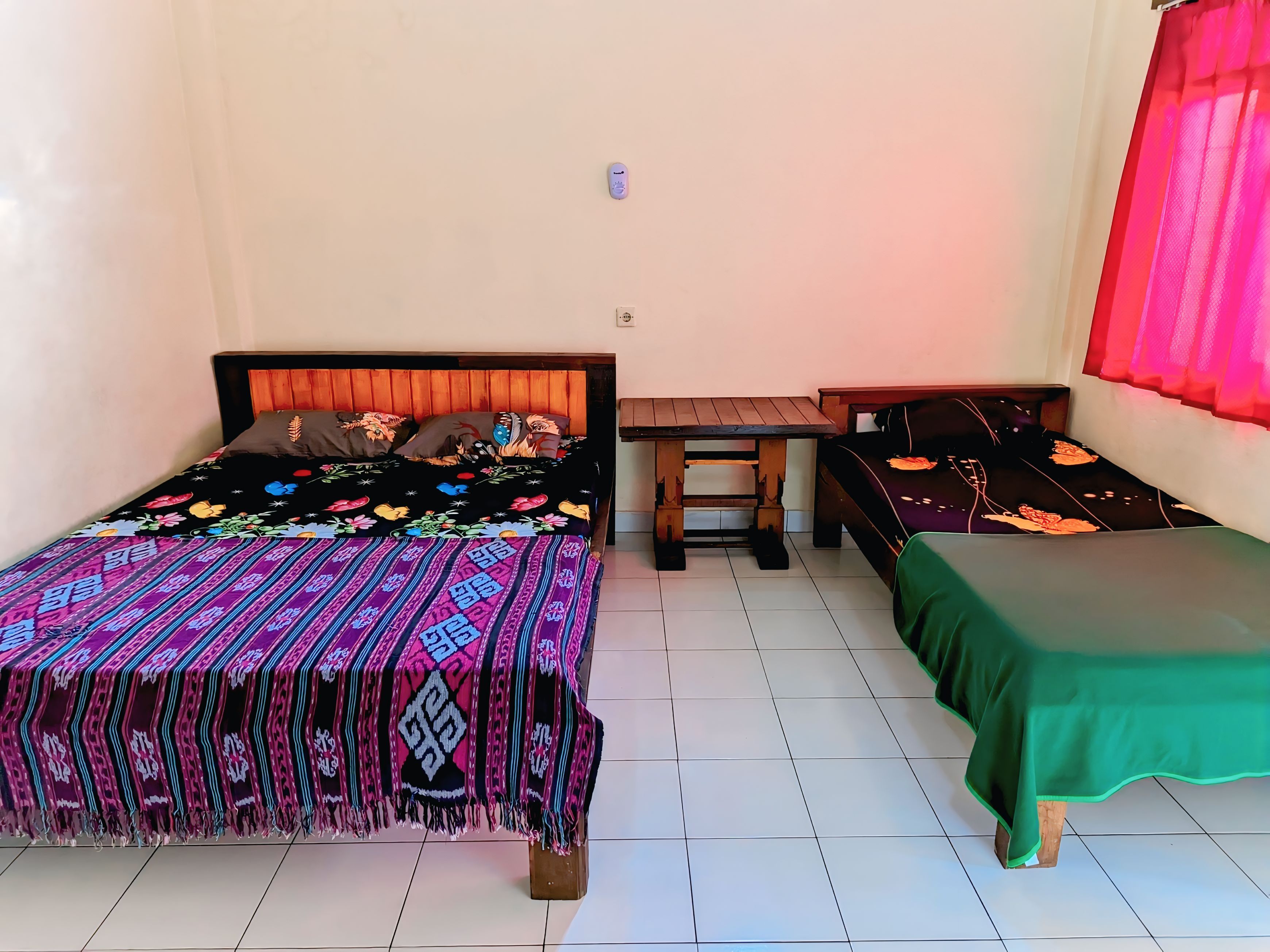 A room with a bed, a small table, and a bench.
