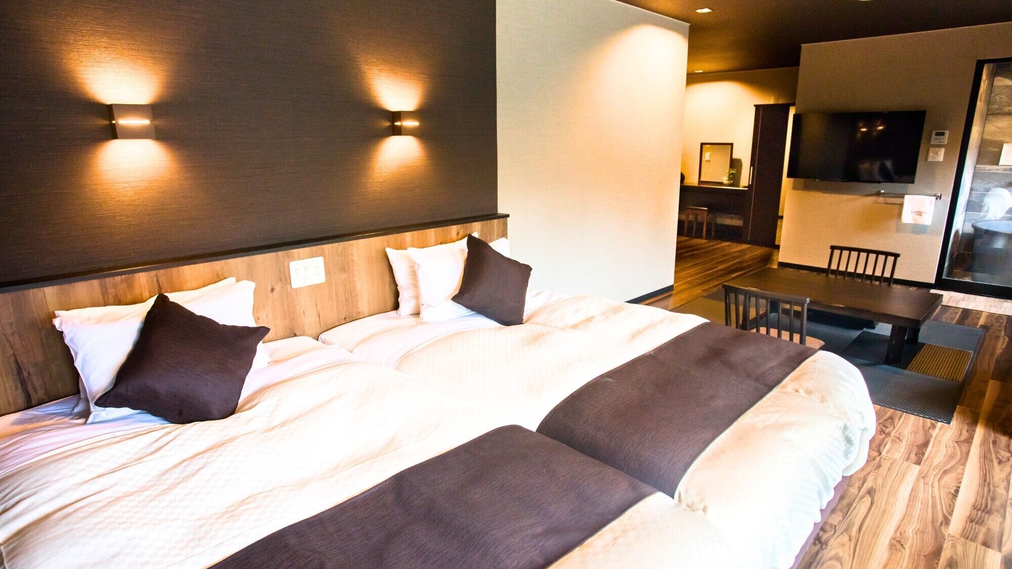 A hotel room with a large bed, a desk, and a television.