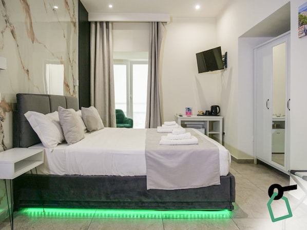 Habitación cuádruple | Edredón, caja de seguridad en la habitación y escritorio