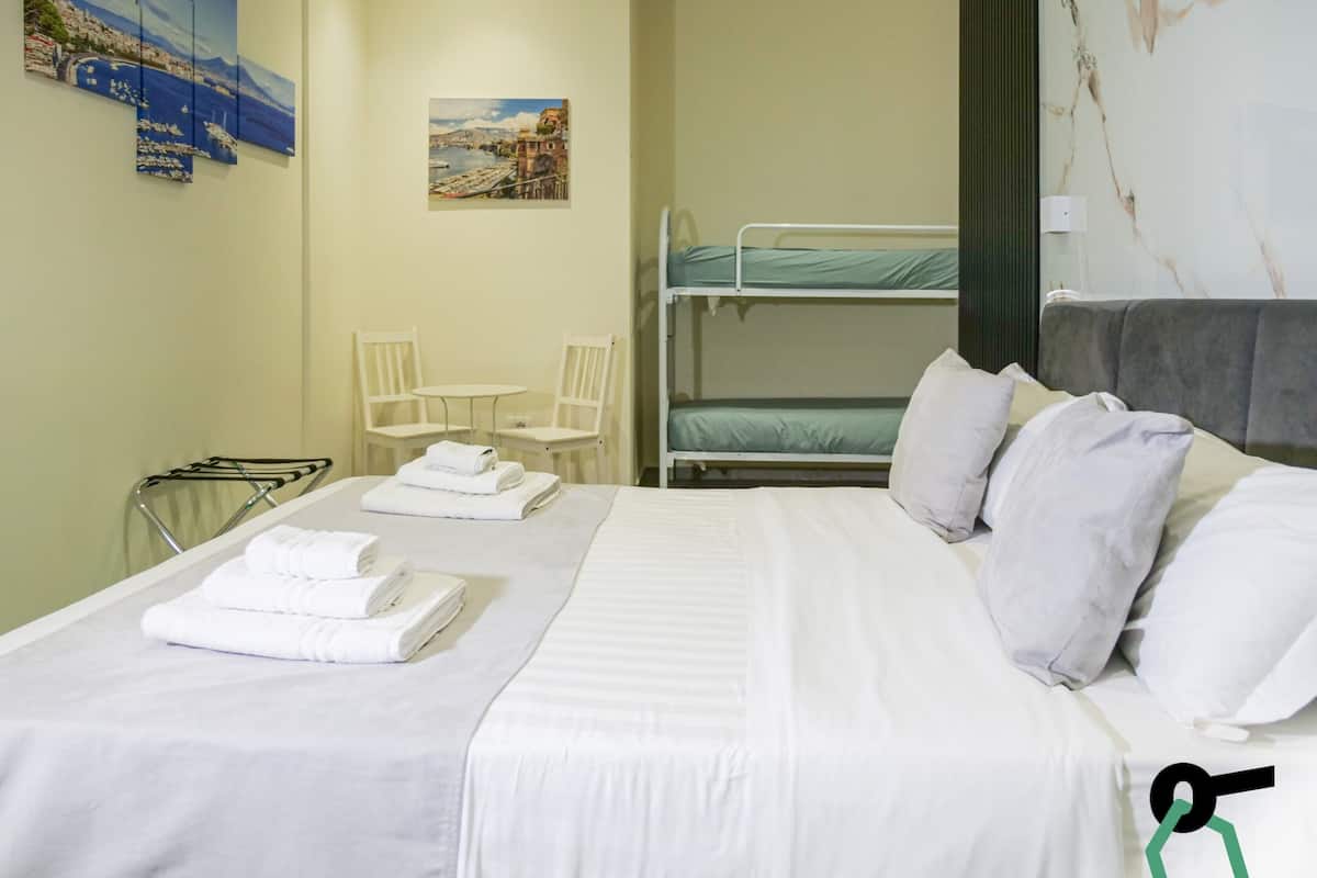 Habitación cuádruple | Edredón, caja de seguridad en la habitación y escritorio