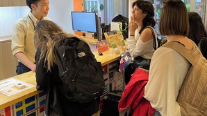 Zona de recepción con un letrero que dice 'RECEPTION', un monitor de computadora y una mesa con varios objetos.