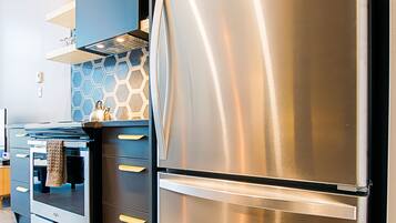 Una cocina moderna con electrodomésticos de acero inoxidable, horno empotrado y salpicadero de forma hexagonal.