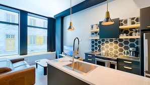 Een moderne keuken met een groot raam, een inbouw kookeiland en een hanglamp.