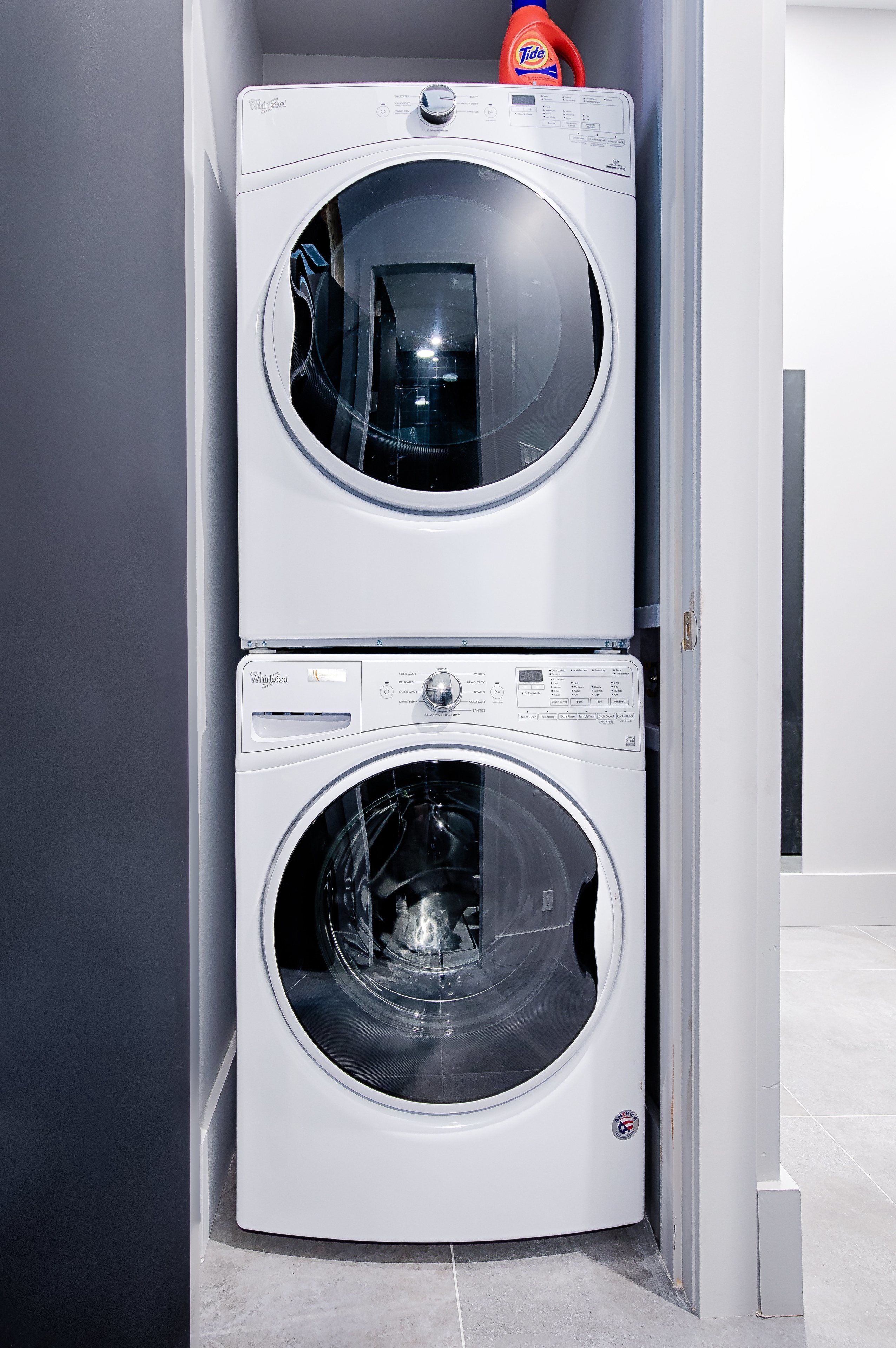 Une machine à laver et un sèche-linge superposés dans une buanderie.