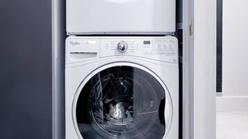 Une machine à laver et un sèche-linge superposés dans une buanderie.