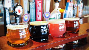 Een bar met verschillende bierglazen op een houten toonbank.