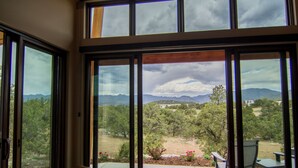 A room with large windows offering a view of a mountainous landscape. - Royal Gorge Cabins (Canon City)