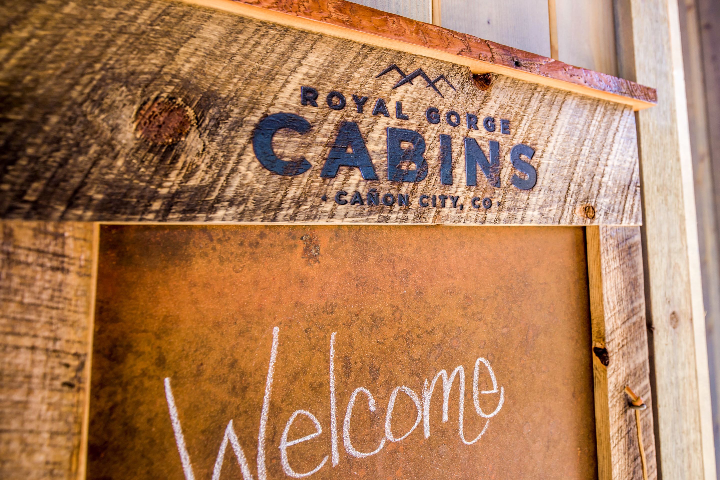 Un letrero de madera con la inscripción "Royal Gorge Cabins" y "Canyon City, CO".