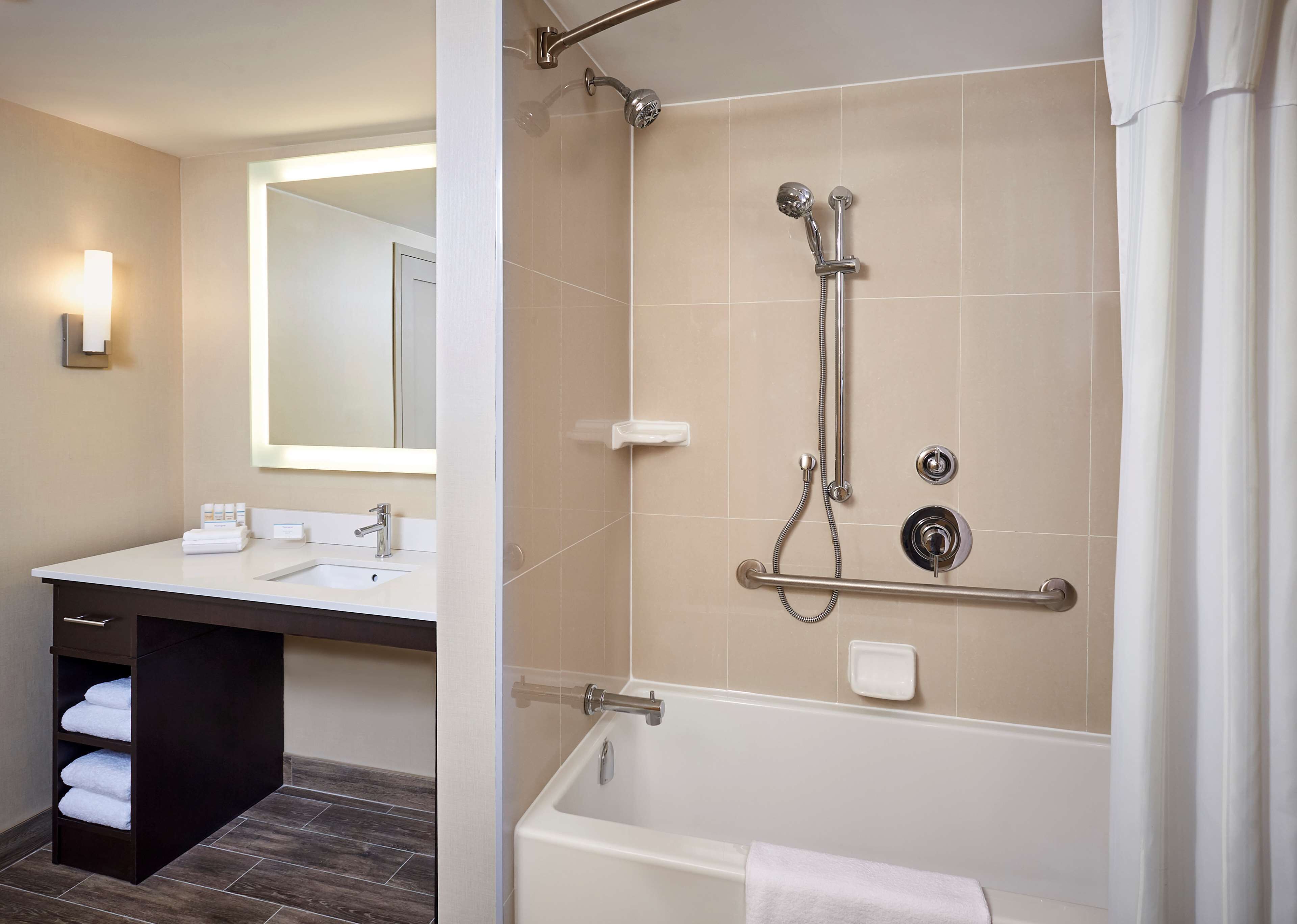 A modern bathroom with a shower, a sink, and a bathtub.