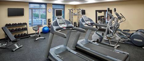 Ett gym med löpband, styrketräningsmaskiner och fria vikter.