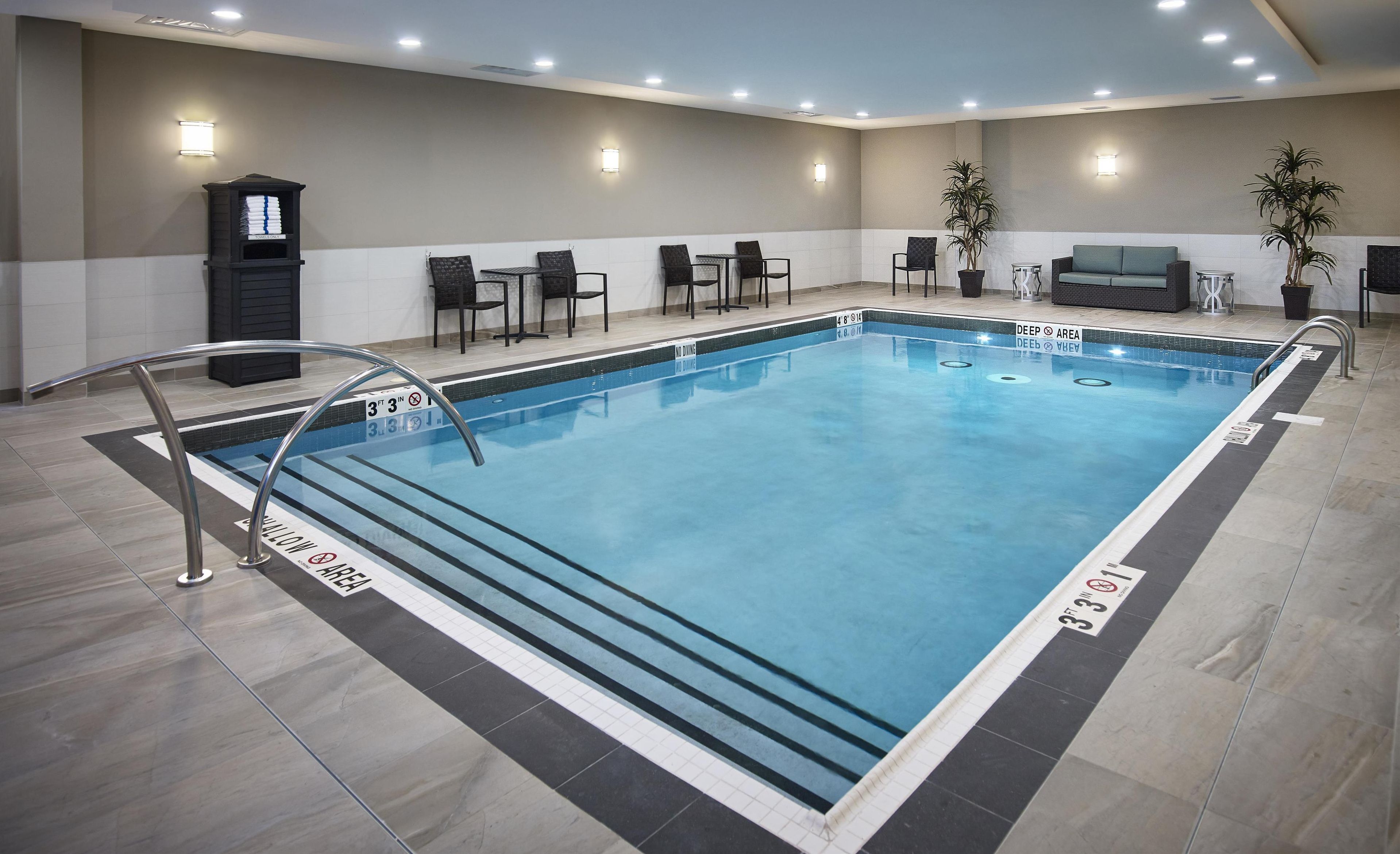 An indoor swimming pool with clear lane markings, a 'No Diving' sign, and a 'Deep Area' label.