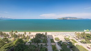 A coastal resort with a beach, palm trees, and a clear view of the ocean. - Citadines Bayfront Nha Trang (Nha Trang)