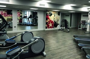 Una palestra con tapis roulant, macchinari ellittici e attrezzature per l'allenamento con i pesi.