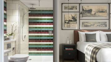 A modern bathroom with a shower, toilet, and a tiled wall with a colorful pattern.