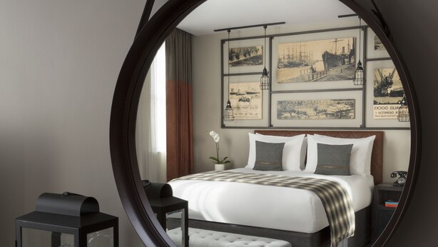 A bedroom with a bed, bedside table, lamp, and wall art. - Hotel Indigo Cardiff by IHG (Cardiff)