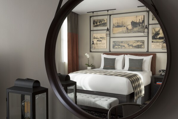 Un dormitorio con cama, mesita de noche, lámpara y decoración en la pared.