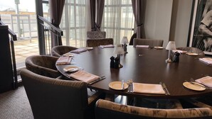 A conference room with a round table, six chairs, and a large window with curtains. - Hotel Indigo Cardiff by IHG (Cardiff)