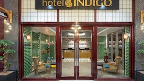 The entrance of Hotel Indigo with a check-in counter, seating area, and potted plants. - Hotel Indigo Cardiff by IHG (Cardiff)