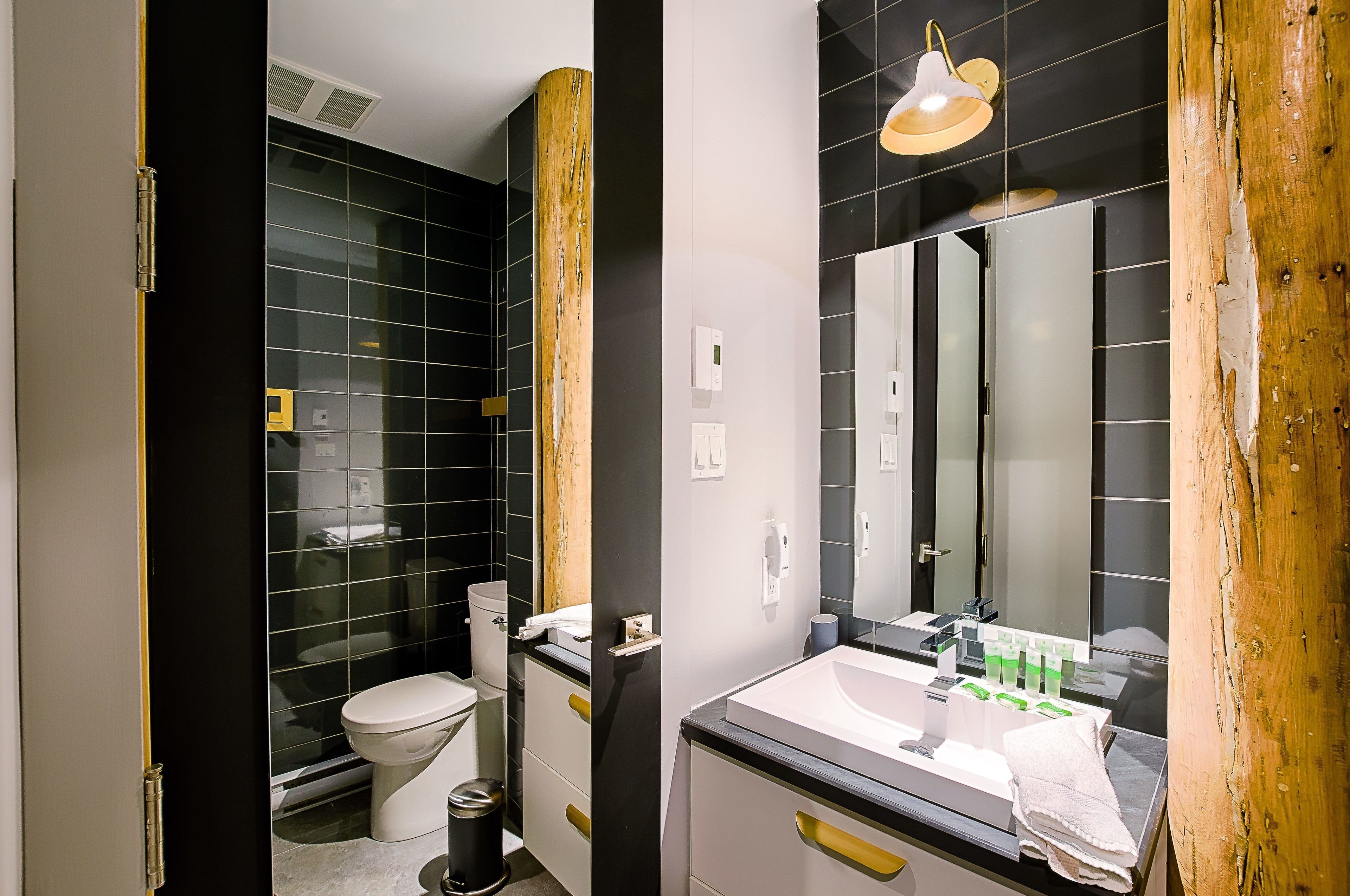 Un baño moderno con inodoro, lavamanos y espejo.