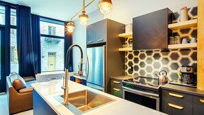 Una cocina moderna con una isla central, electrodomésticos de acero inoxidable y un salpicadero hexagonal.