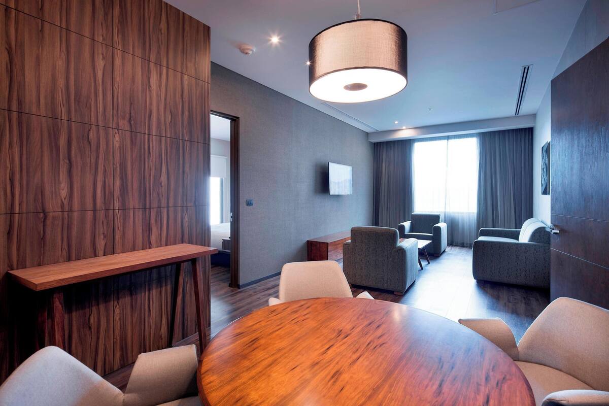 Une salle de conférence moderne, dotée d’une table en bois, de chaises et d’un grand lampadaire.
