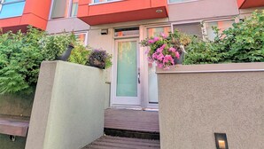 A modern building with a red facade, large windows, and a front entrance with steps leading up to it. - Monki Di Executive Suites - GLAS - Luxury Inner City Home 3 min to Downtown w Private Rooftop Patio Fireplace (Calgary)