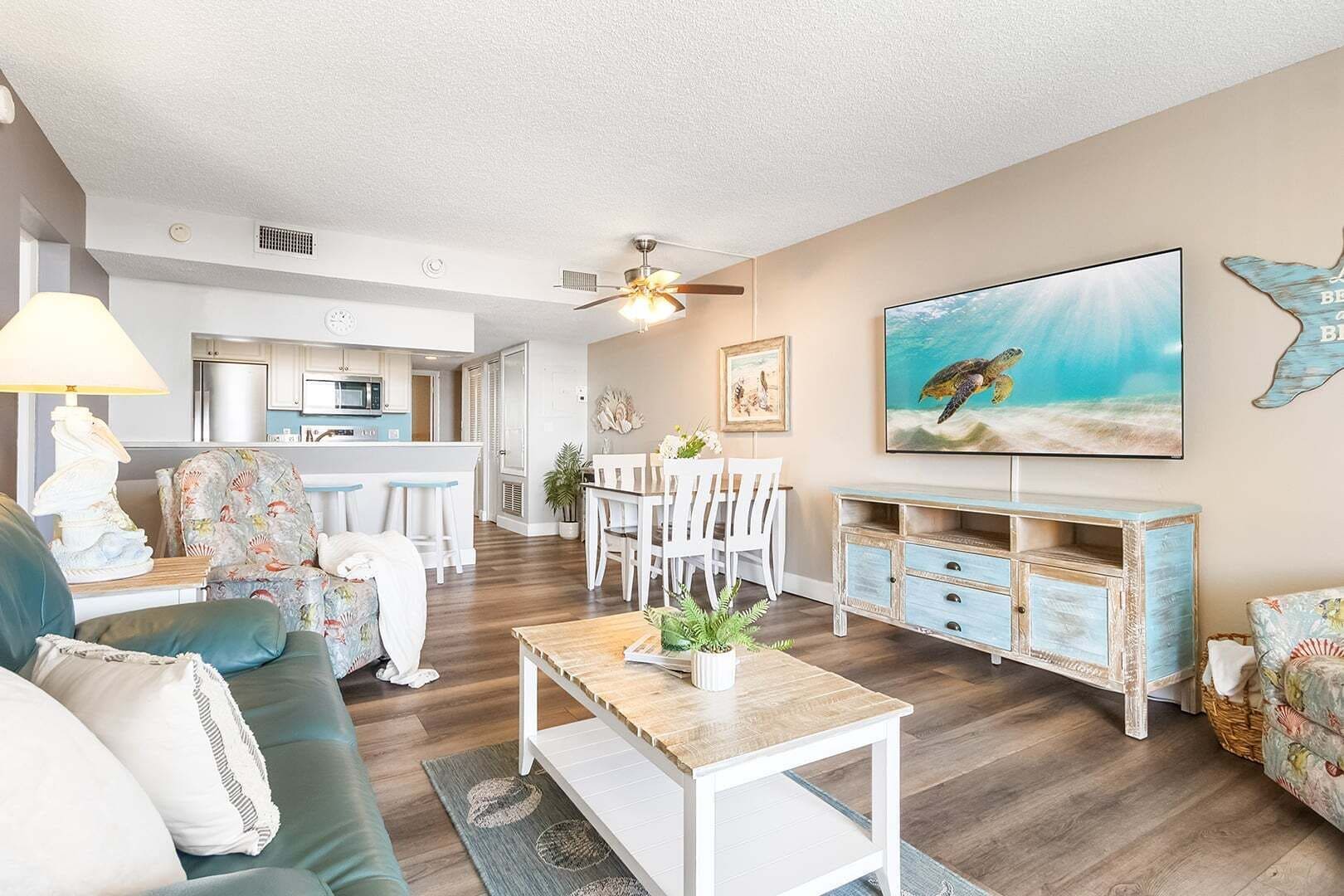 A living room with a sofa, coffee table, and a TV mounted on the wall.