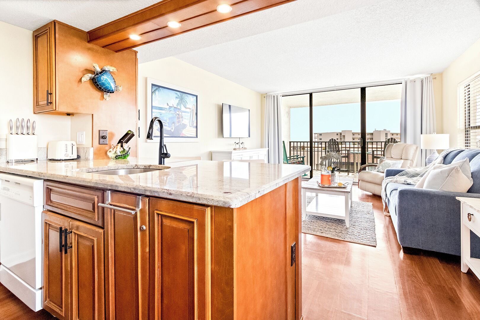 Cocina moderna con armarios de madera, una isla grande y vista al balcón.