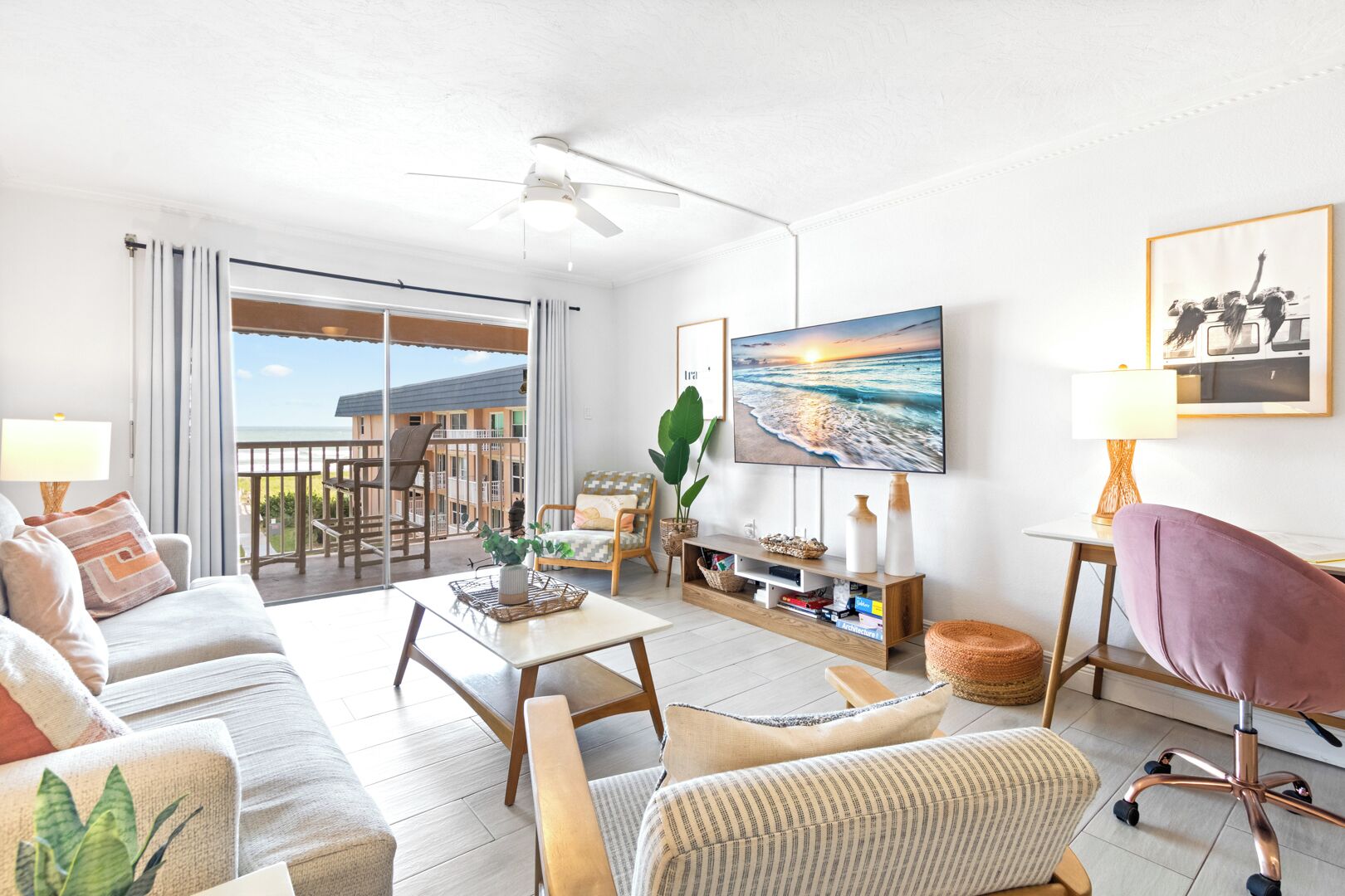 A spacious living room with a balcony, a flat-screen TV, and a comfortable seating area.