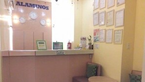 A small reception area with a 'Cashier' sign, a clock, and framed certificates on the wall. - Asia Novo Boutique Hotel - Alaminos (Alaminos)