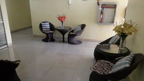 A modern living room with a sofa, two chairs, a small table, and a vase with flowers. - Asia Novo Boutique Hotel - Alaminos (Alaminos)