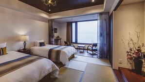 Habitación de hotel con dos camas, un escritorio, una silla y vistas a la ciudad.