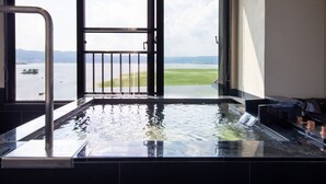 Un jacuzzi con vistas a un lago y montañas.