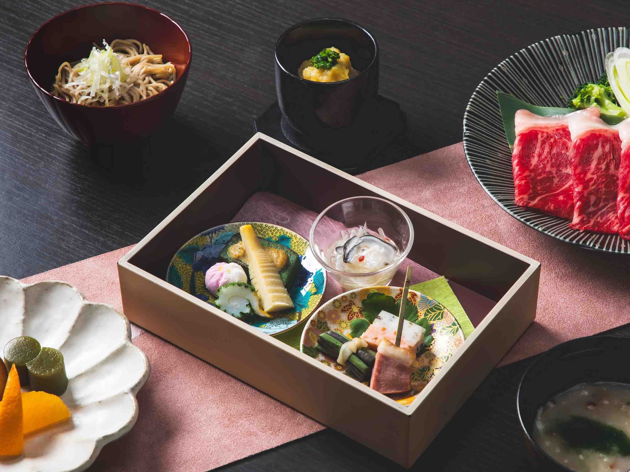 En traditionell japansk måltid med olika rätter, inklusive sushi, sashimi och en skål soppa.