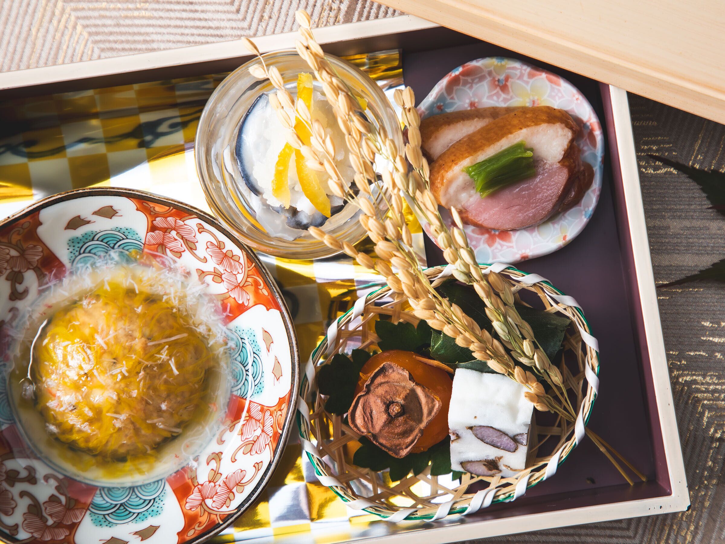 A tray with various food items including a bowl of soup, a dish with meat and vegetables, and a small container with a yellow substance.