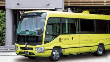 Un autobus jaune est garé devant un immeuble doté d’une grande fenêtre et d’une porte.