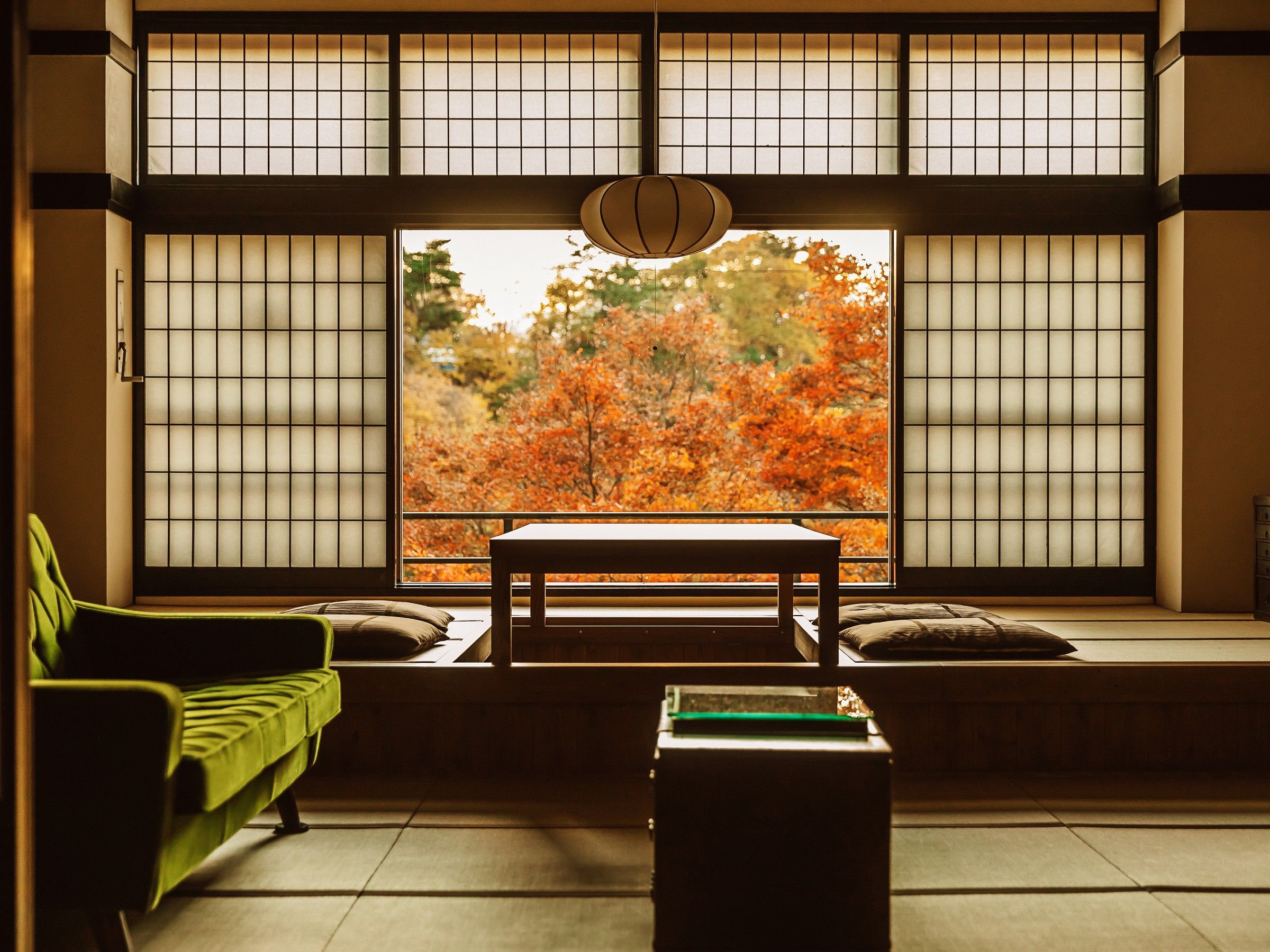 Una habitación japonesa tradicional con suelo de tatami, una mesa baja y un sofá.