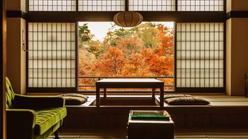 Una habitación japonesa tradicional con suelo de tatami, una mesa baja y un sofá.