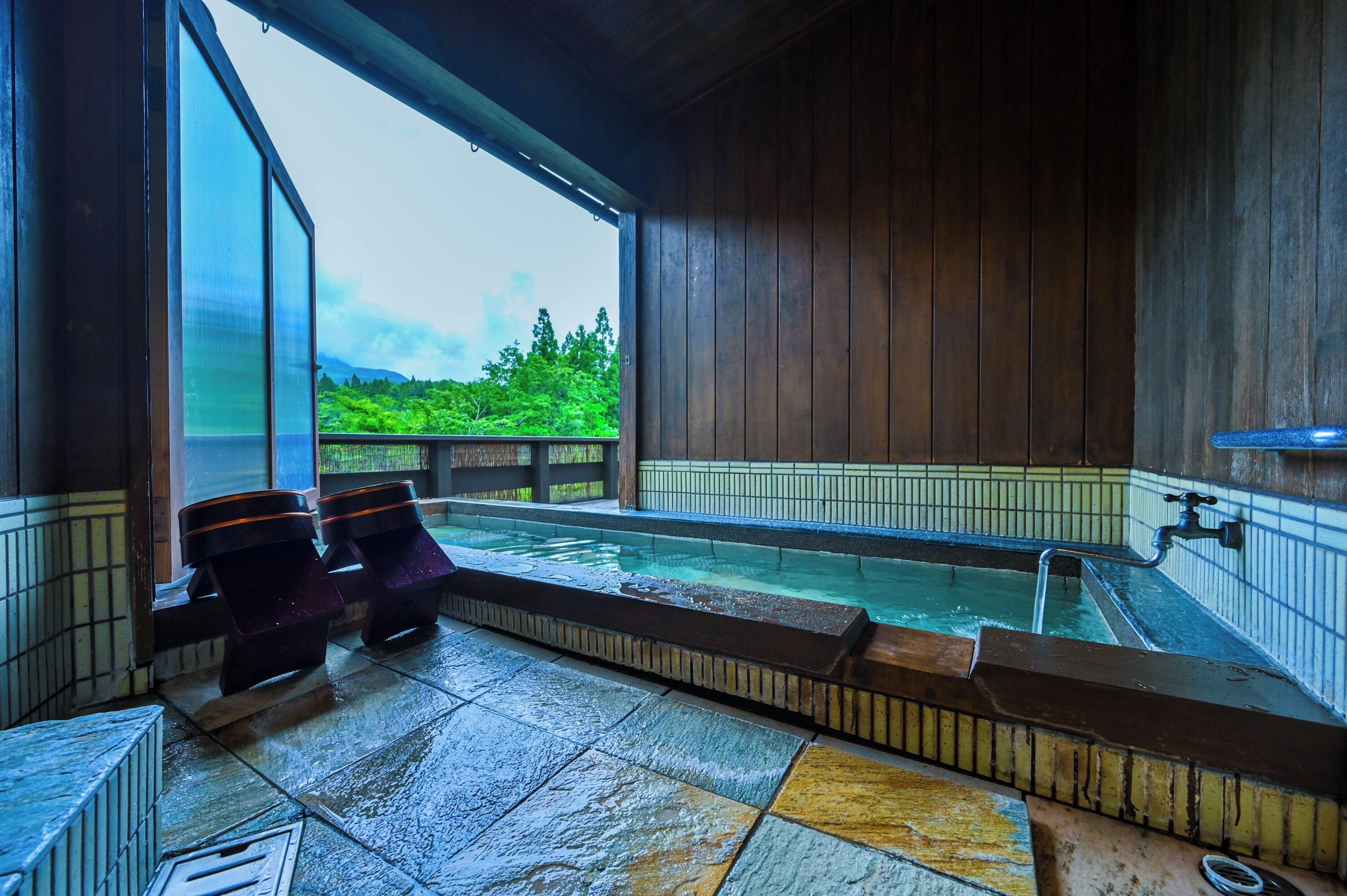 A hot tub area with a view of greenery outside.