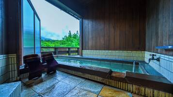A hot tub area with a view of greenery outside.