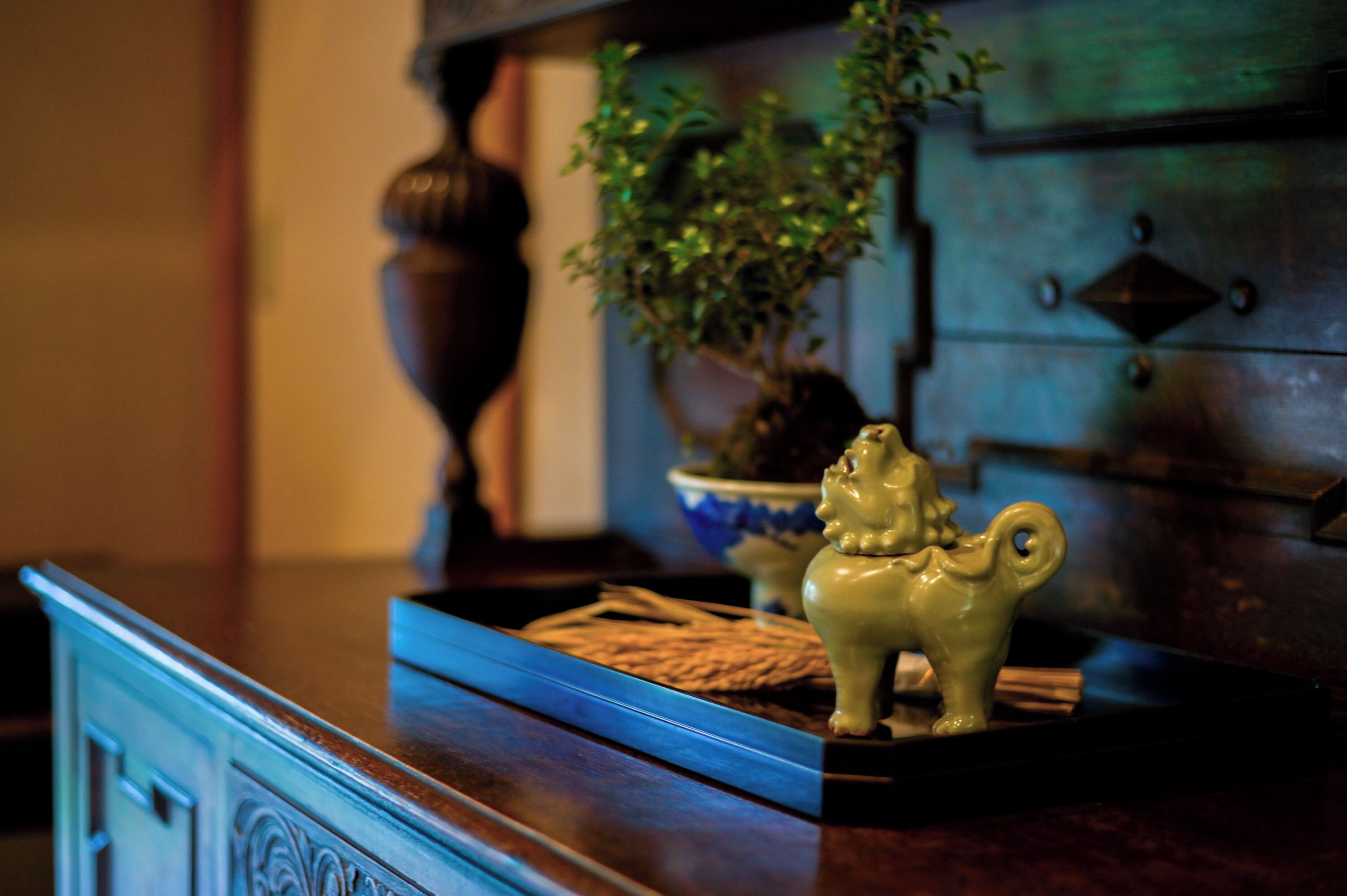 Un aparador de madera con un mueble azul, un jarrón decorativo y una planta pequeña.