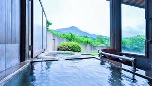 A hot tub with a view of a mountain and greenery.