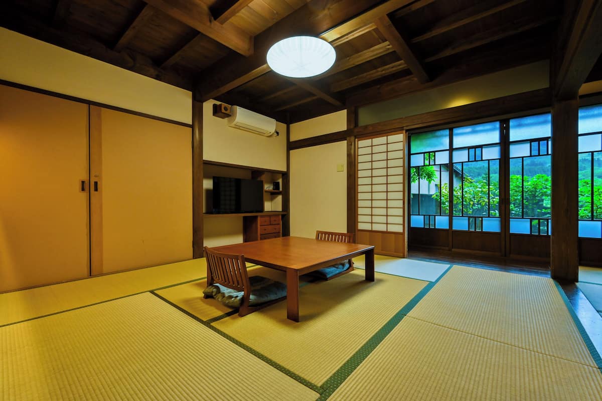 Une pièce de style japonais traditionnel, avec un sol recouvert de tatamis, une basse table en bois et des portes coulissantes.