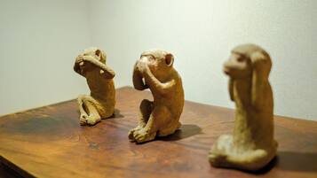Three small, beige, seated figurines on a wooden surface.