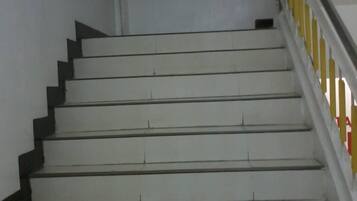 Una escalera con peldaños blancos y bordes negros que conduce a una plataforma.