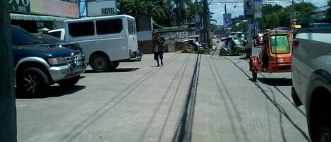 A street with a white van parked in front of a building labeled "Hotel".