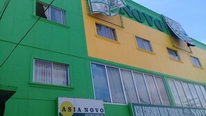 A building with a green and yellow facade, featuring signs for 'ASIANOVO BOUTIQUE HOTEL INC.' and 'ASIA CONSUMER VALUE TRADING INC.' - Asia Novo Boutique Hotel - Roxas (Roxas City)