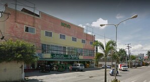 Un edificio de varios pisos con un llamativo letrero que dice 'NOVO' en la fachada.