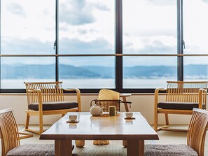 Una habitación con un ventanal grande, una mesa de madera y cuatro sillas.