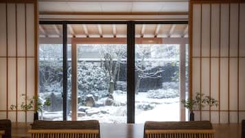 Habitació japonesa tradicional amb terra de tatami, una taula baixa i portes corredisses.